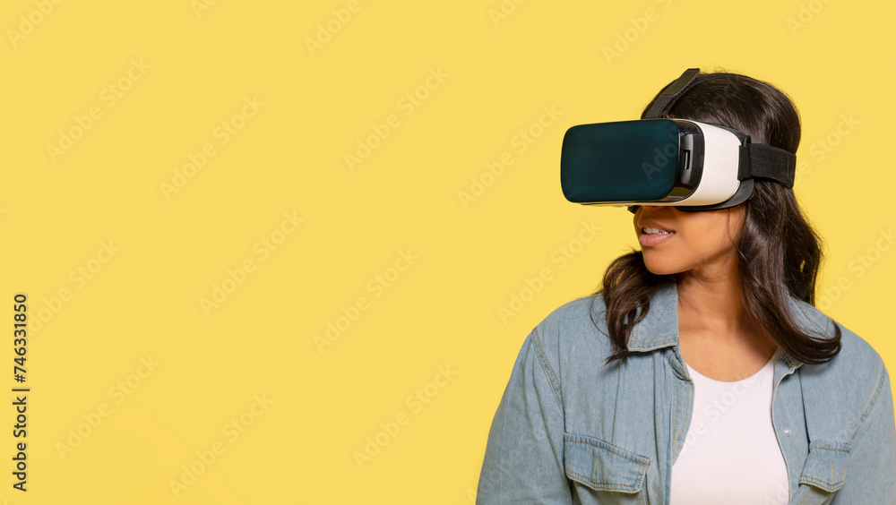 female in modern VR headset exploring virtual reality universe on yellow background female in modern VR headset exploring virtual reality universe on yellow background