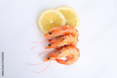 Delicious cooked shrimps and lemon isolated on white, top view