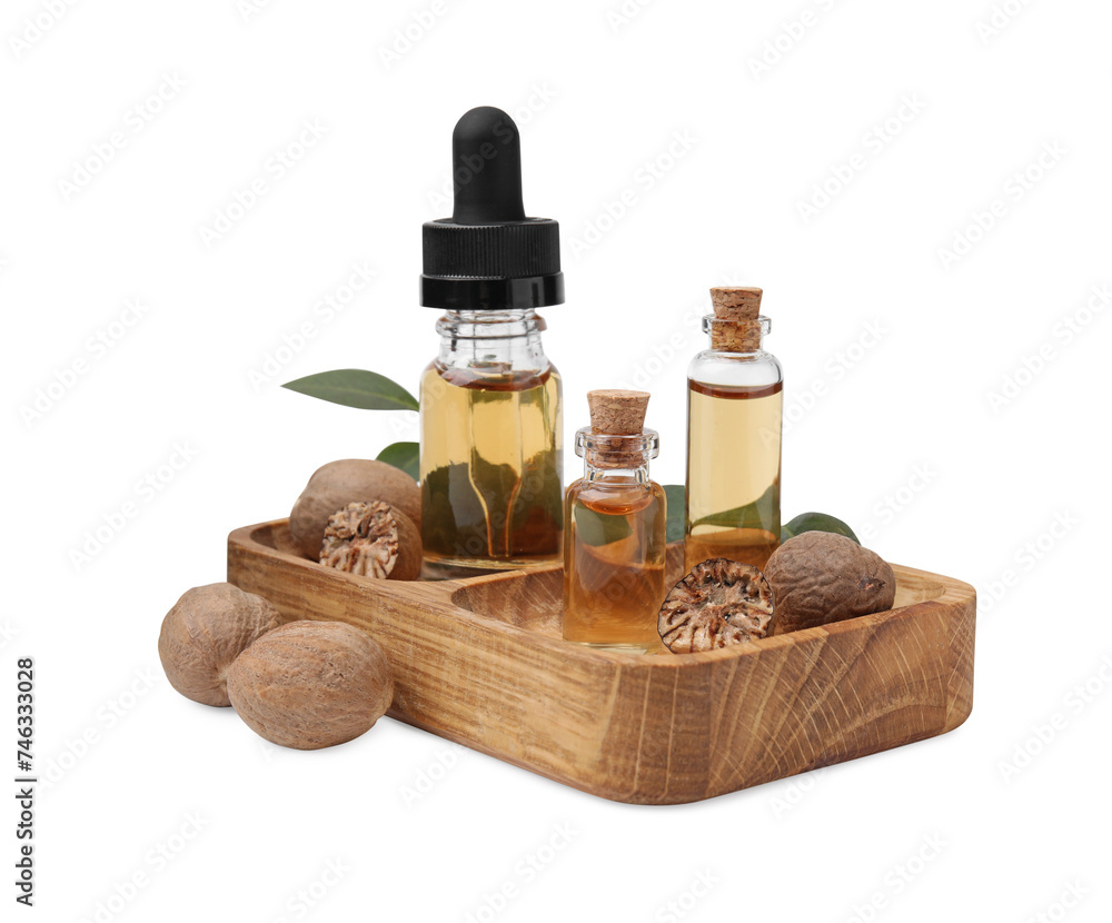 Nutmeg essential oil, nuts and leaves isolated on white Nutmeg essential oil, nuts and leaves isolated on white