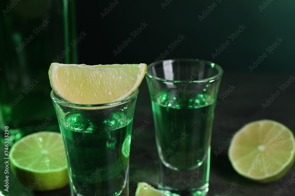 Absinthe in shot glasses and lime on table, closeup. Alcoholic drink Absinthe in shot glasses and lime on table, closeup. Alcoholic drink