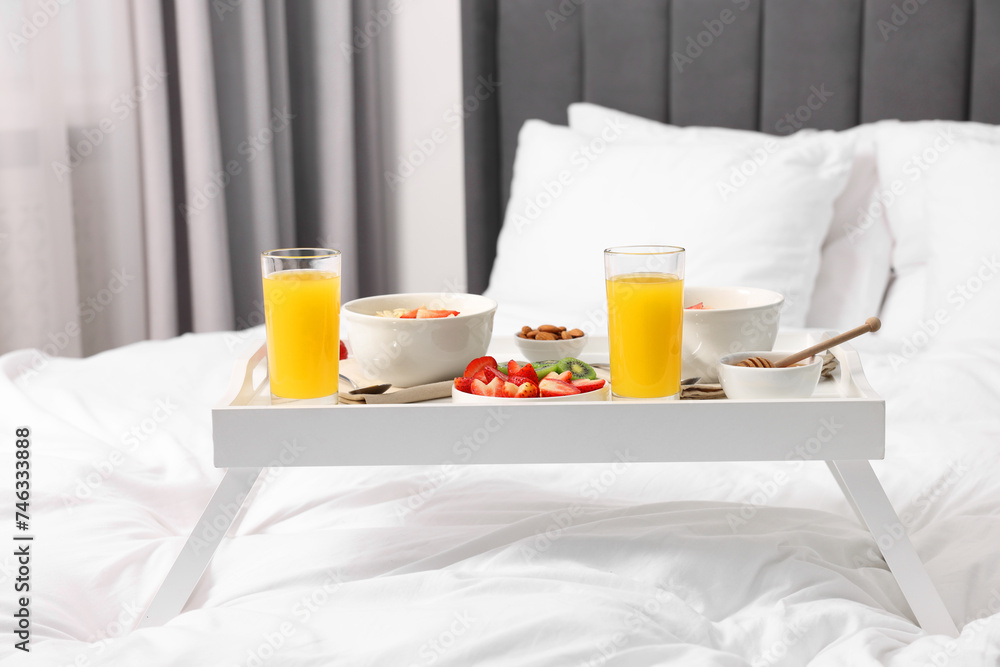 Tray with tasty breakfast on bed at home Tray with tasty breakfast on bed at home