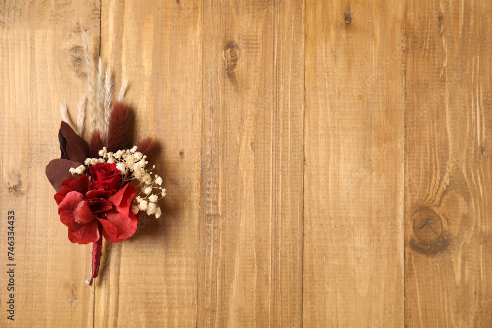 Beautiful boutonniere on wooden background, top view. Space for text Beautiful boutonniere on wooden background, top view. Space for text