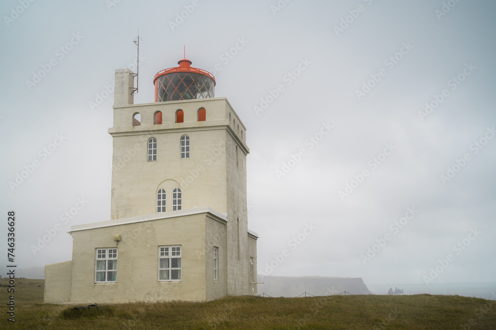 Dramatic shot of Dyrholaey Lighthouse. Iceland on a rainy day. Autumn landscape with copy space