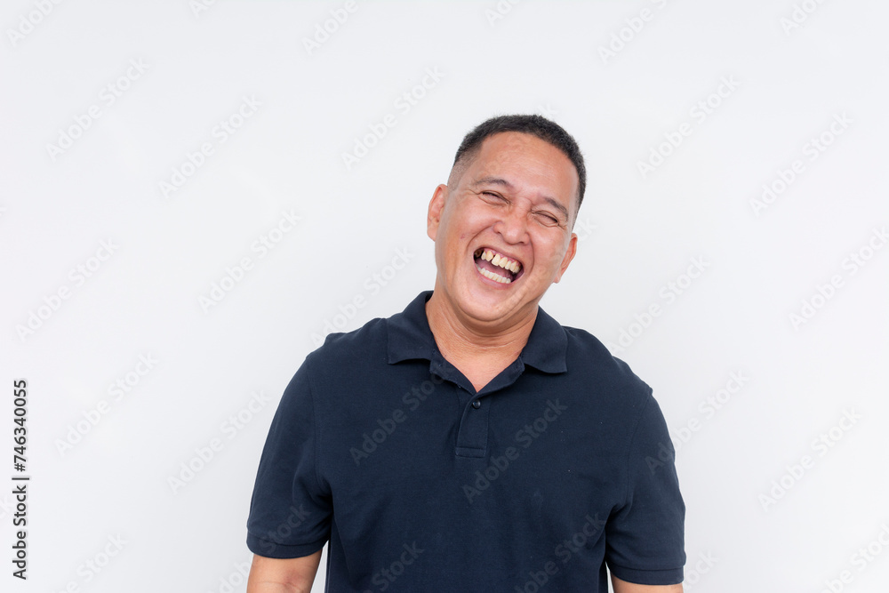 Fototapeta premium Portrait of a cheerful middle-aged Asian man laughing heartily, with a white background providing copy space.