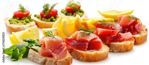 A variety of different types of food including tuna appetizer, bread, lemon, and vegetables are arranged neatly on a white surface.