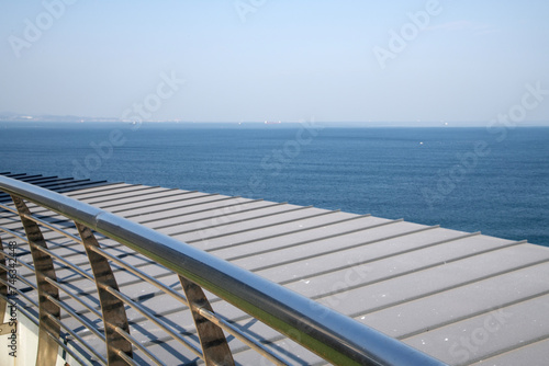 seascape above the building roof with metal fence
