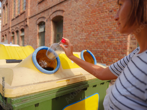 Konstfotografi woman throwing plastic bottle Recycling bin stand on european street