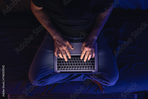 Close up of hacker hand stealing data, man networking on laptop late at night.