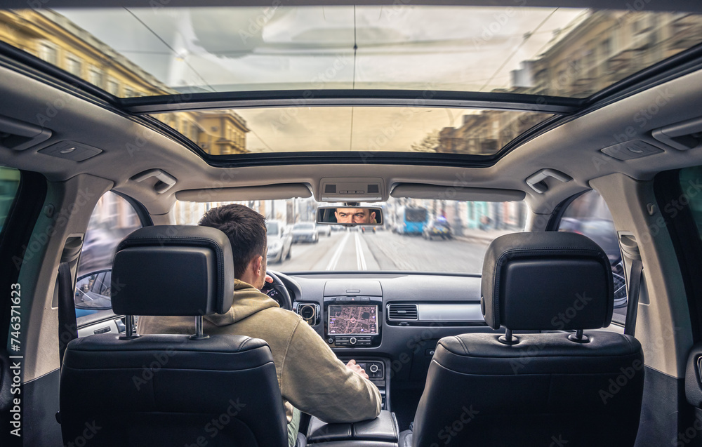 A male driver drives at speed through the streets of the city. A male driver drives at speed through the streets of the city.