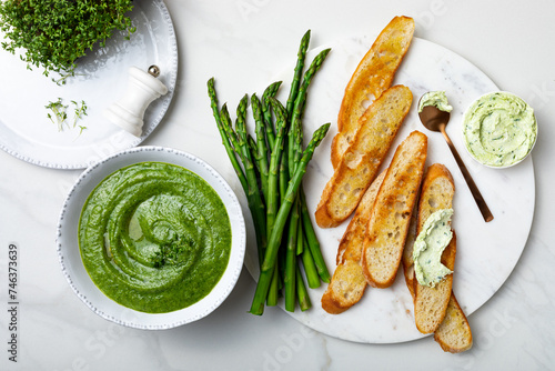 Healthy asparagus, green peas, watercress cream soup with toasted bread and wild garlic, ramson cream cheese