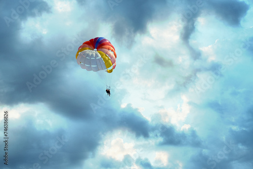 Couple is parasailing in the blue sky. Summer vacation on the Black Sea.