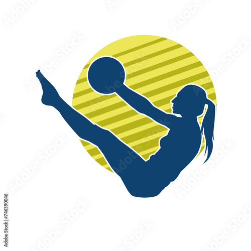 Silhouette of a slim sporty woman doing pilates exercise using gym ball. Silhouette of a sporty female doing physical exercise using fitness ball. 