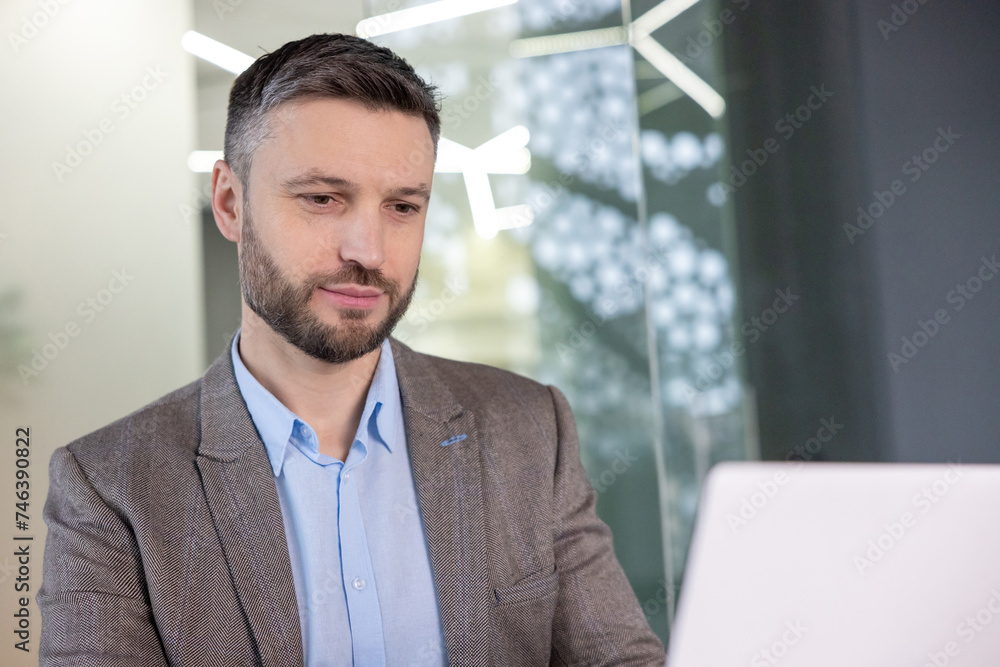 Professional businessman working on laptop in modern office space Professional businessman working on laptop in modern office space