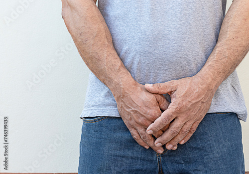 Man's hand holding his urethra in pain clenched Prostate cancer, enlarged prostate, urethritis, health care concept