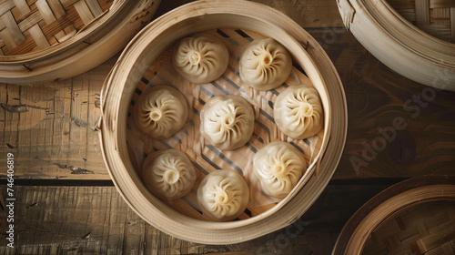 Oriental dumplings with meat and broth lying in a bamboo steamer on a wooden table top view