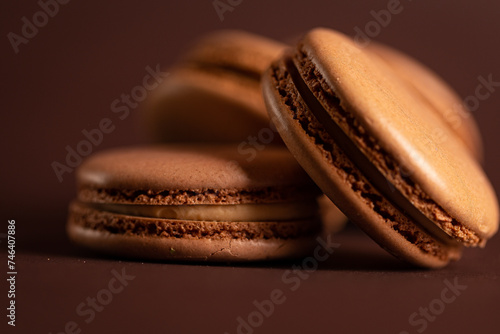 four brown coffee macaron on a brown background