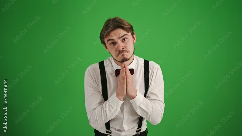 Young Man Gesturing for a Small Request on Green Background Young Man Gesturing for a Small Request on Green Background