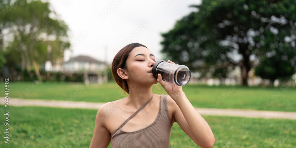 Drinking water, fitness and exercise woman after sports run and training in nature. Workout