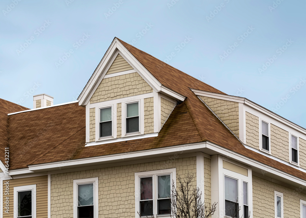 Dormer windows on the sloped shingle roof of a newly built house in Brighton, MA, USA Dormer windows on the sloped shingle roof of a newly built house in Brighton, MA, USA