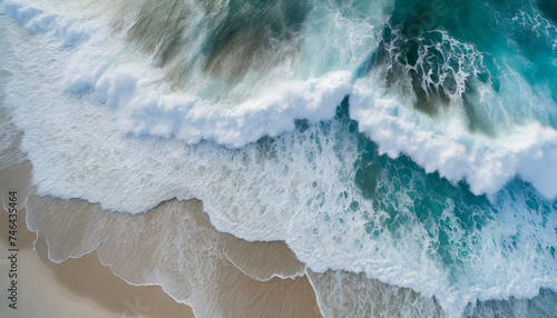Drone style photo from above of ocean waves breaking on a sandy beach