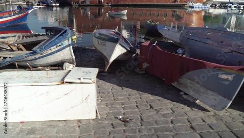 Small wooden boats in the port, filming with a steadicam, moving from left to right.