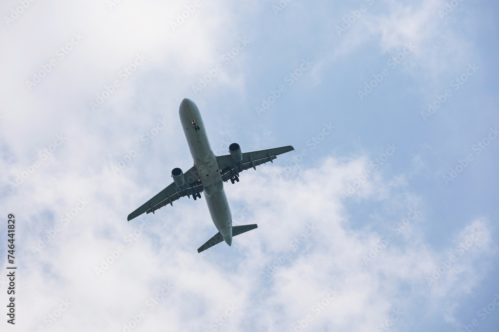 Airplane flying in sky with white clouds. Passenger plane at flight, travel concept