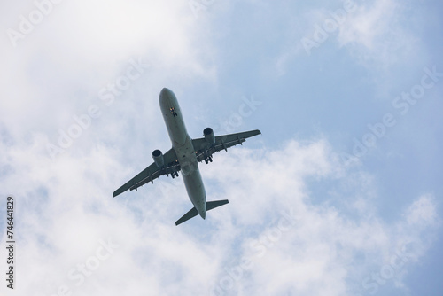 Airplane flying in sky with white clouds. Passenger plane at flight, travel concept