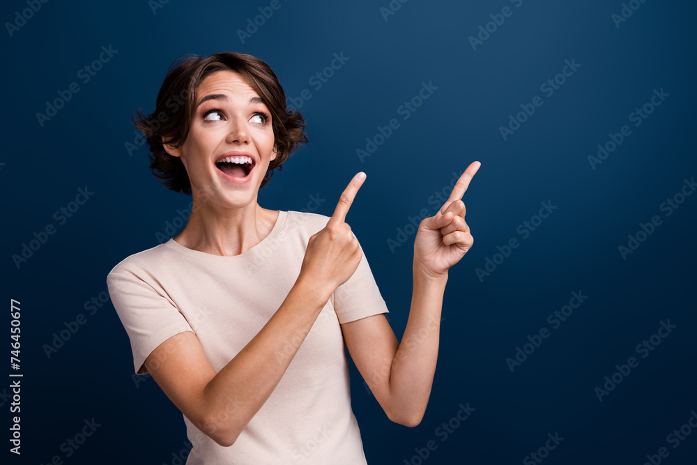 Portrait of funny interested girl directing fingers look blank space amazing news open mouth isolated dark blue color background Portrait of funny interested girl directing fingers look blank space amazing news open mouth isolated dark blue color background