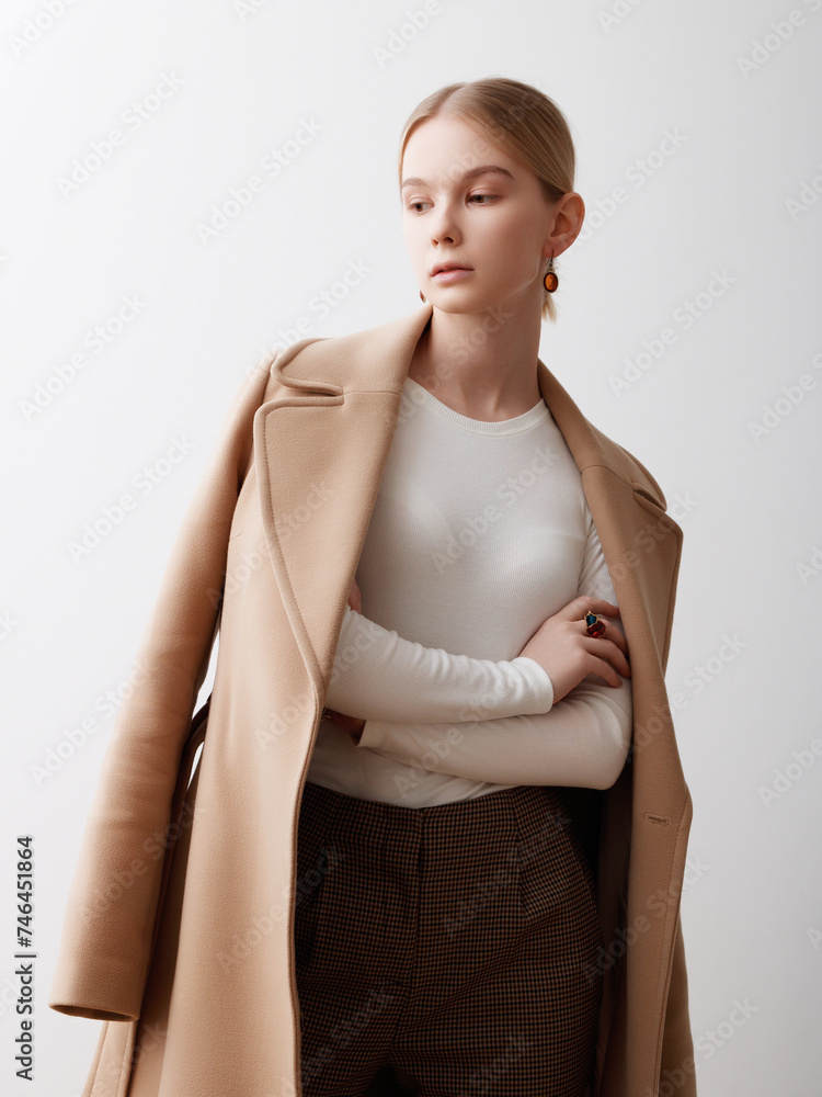 Fashion studio photo of young beautiful lady in beige coat on white background. Total beige. Fashion look book. Warm Autumn. Warm Spring Fashion studio photo of young beautiful lady in beige coat on white background. Total beige. Fashion look book. Warm Autumn. Warm Spring