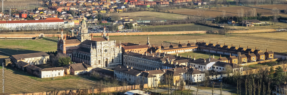 Aerial shot over Certosa di Pavia monastery with lawn fields in Italy, Pavia