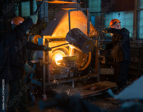 Pouring molten metal into a centrifugal machine in the foundry shop of metallurgical plant
