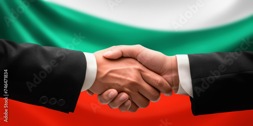 Businessman, diplomat in suits clasp hands for handshake over Bulgaria flag, agree on united success in trade, diplomacy, cooperation, negotiation, support, teamwork in commerce, gesture of greeting