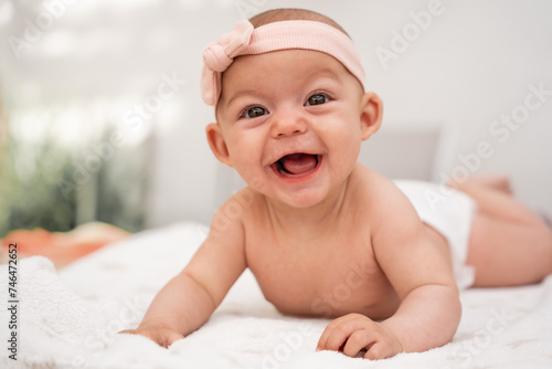 Close-up portrait of a laughing baby with his mouth open lying on a blanket. Concept of learning and development in childhood. educate positively. secure attachment. respectful parenting