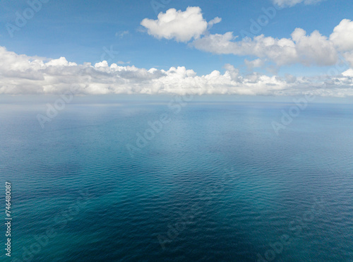 Blue sea surface with corals. Blue sky and clouds. Boracay, Philippines.