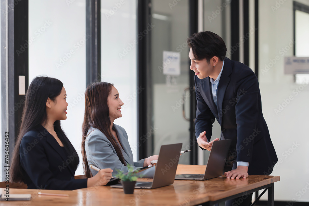 Handsome Asian businessman presenting his idea to his teammate in the meeting room.