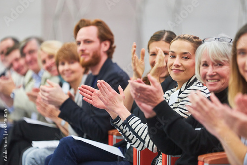 Professionals applauding at business event in auditorium