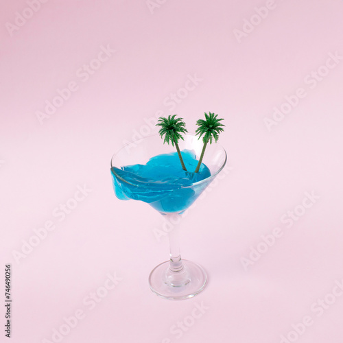 Martini glass with palms on pink background. Summer and enjoy holiday concept. 