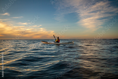 Sunset paddler out at sea