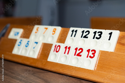 Board game, numbers and colours on a wooden floor. Rummikub, a board game. photo