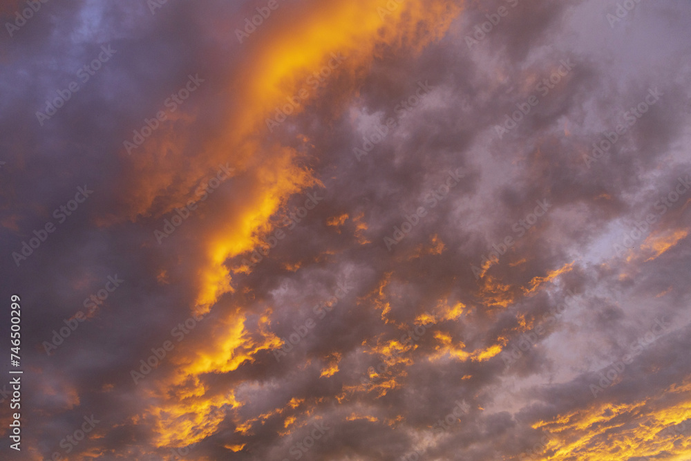 evening sky at sunset with yellow and purple cumulus and perispheric clouds evening sky at sunset with yellow and purple cumulus and perispheric clouds