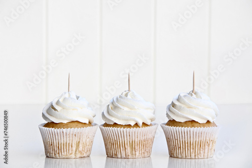 Three Vanilla Cupcakes Topper Mockup. 3 cupcake with wooden toothpick in white background Copy space for your design here. Blank mockup for advertising and promotions