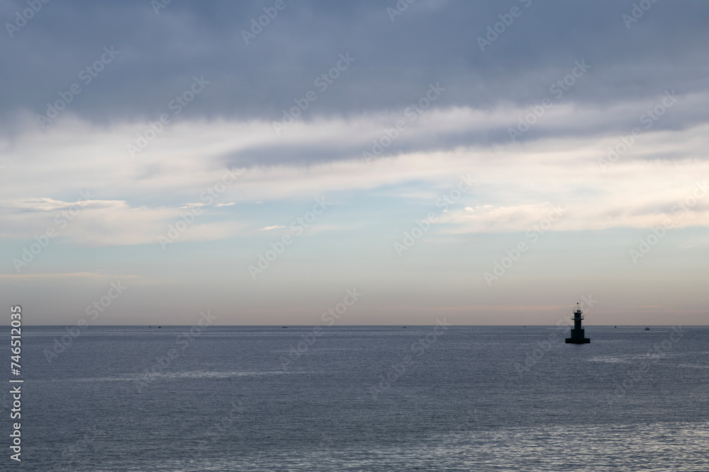 Seascape with the clouds, horizon, and lighthouse Seascape with the clouds, horizon, and lighthouse