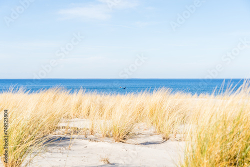 Fototapeta Naklejka Na Ścianę i Meble -  Dune landscape at the baltic sea in Lubmin with ocean in the background and a small fisher boat on the water