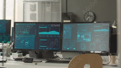 No people shot of cybersecurity officer workplace with two computer monitors with secret network data program on screen and portable radio set on desk photo