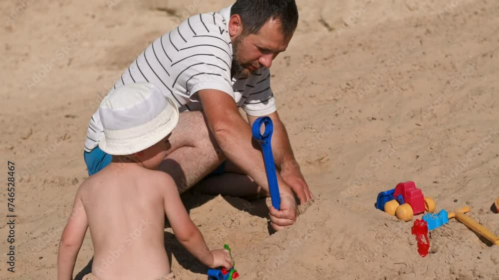 Father and 3 years son on beach building sand castle with plastic toys . single father solo parent. Involved parenting. Relaxing and playing outdoors with family Father and 3 years son on beach building sand castle with plastic toys . single father solo parent. Involved parenting. Relaxing and playing outdoors with family