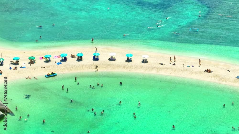Tourists unwind on a secluded sandbar, encircled by transparent waters, immersing themselves in the serene tranquility of coastal paradise. Flight over the ocean. Koh Nangyuan, Thailand. 4K. Tourists unwind on a secluded sandbar, encircled by transparent waters, immersing themselves in the serene tranquility of coastal paradise. Flight over the ocean. Koh Nangyuan, Thailand. 4K.