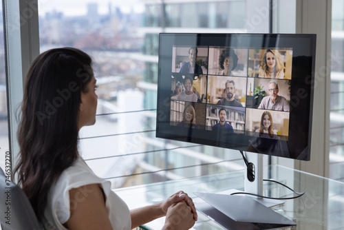 Businesswoman Using Video Conferencing technology for video call with colleagues working remotely photo