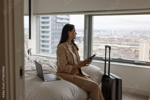 Business executive in hotel working using her cell phone photo
