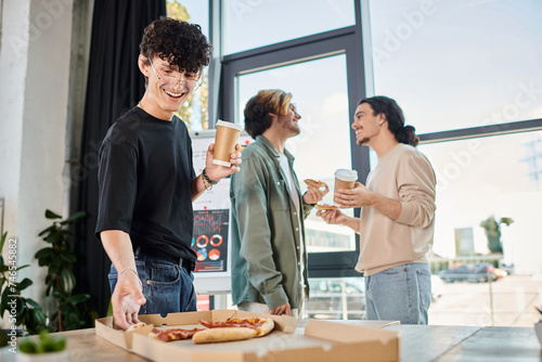happy team member with coffee taking slice of pizza in friendly office atmosphere, lunch break