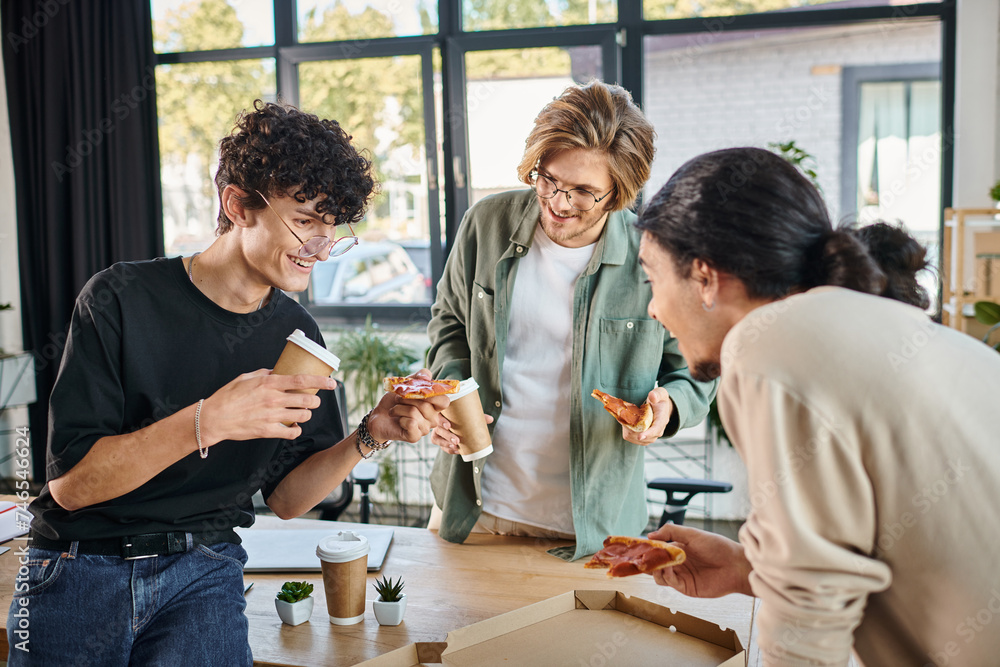 smiling men enjoying a pizza in a friendly and relaxed atmosphere, startup team having lunch break smiling men enjoying a pizza in a friendly and relaxed atmosphere, startup team having lunch break